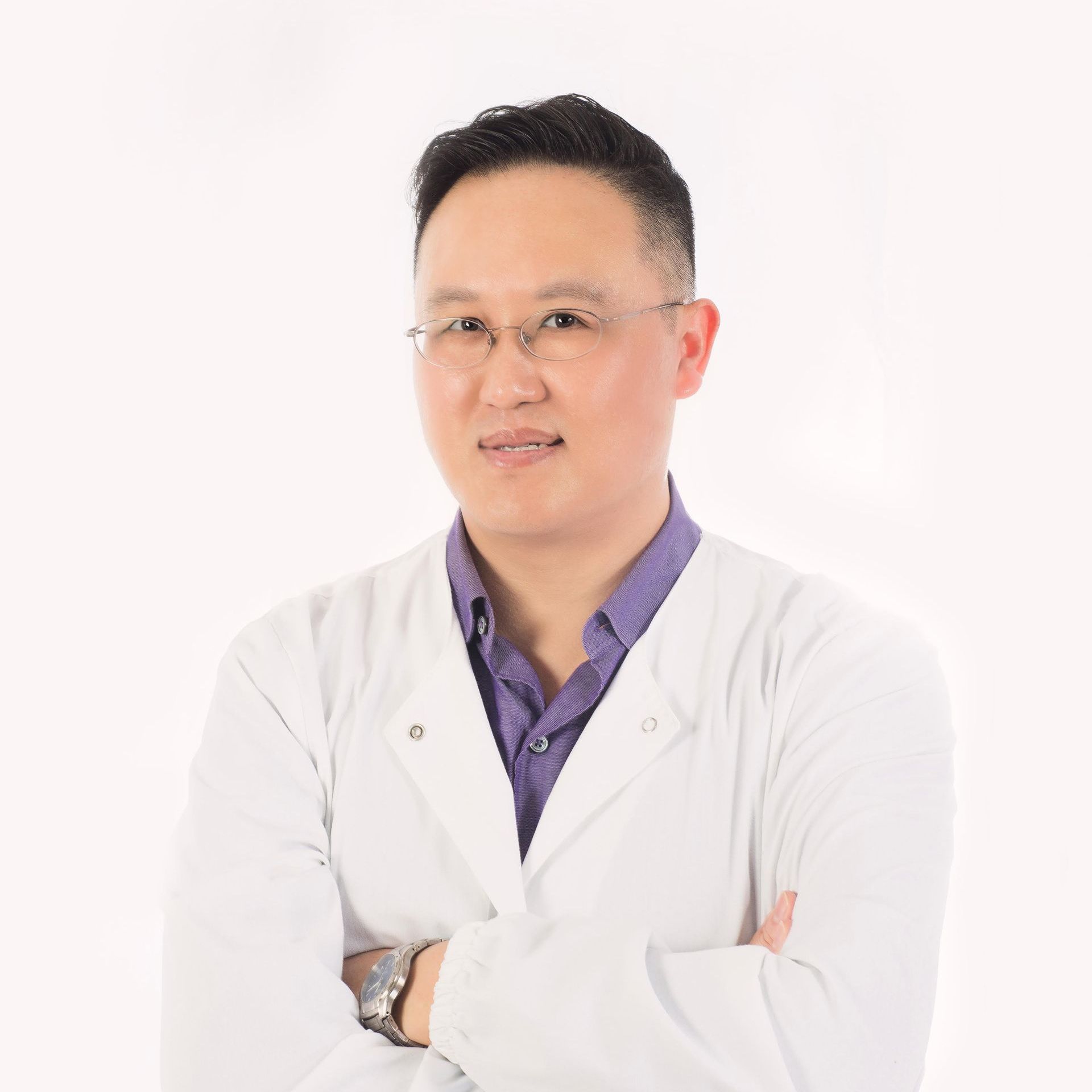 Dr. Cho in a white coat and purple shirt is standing with his arms crossed .