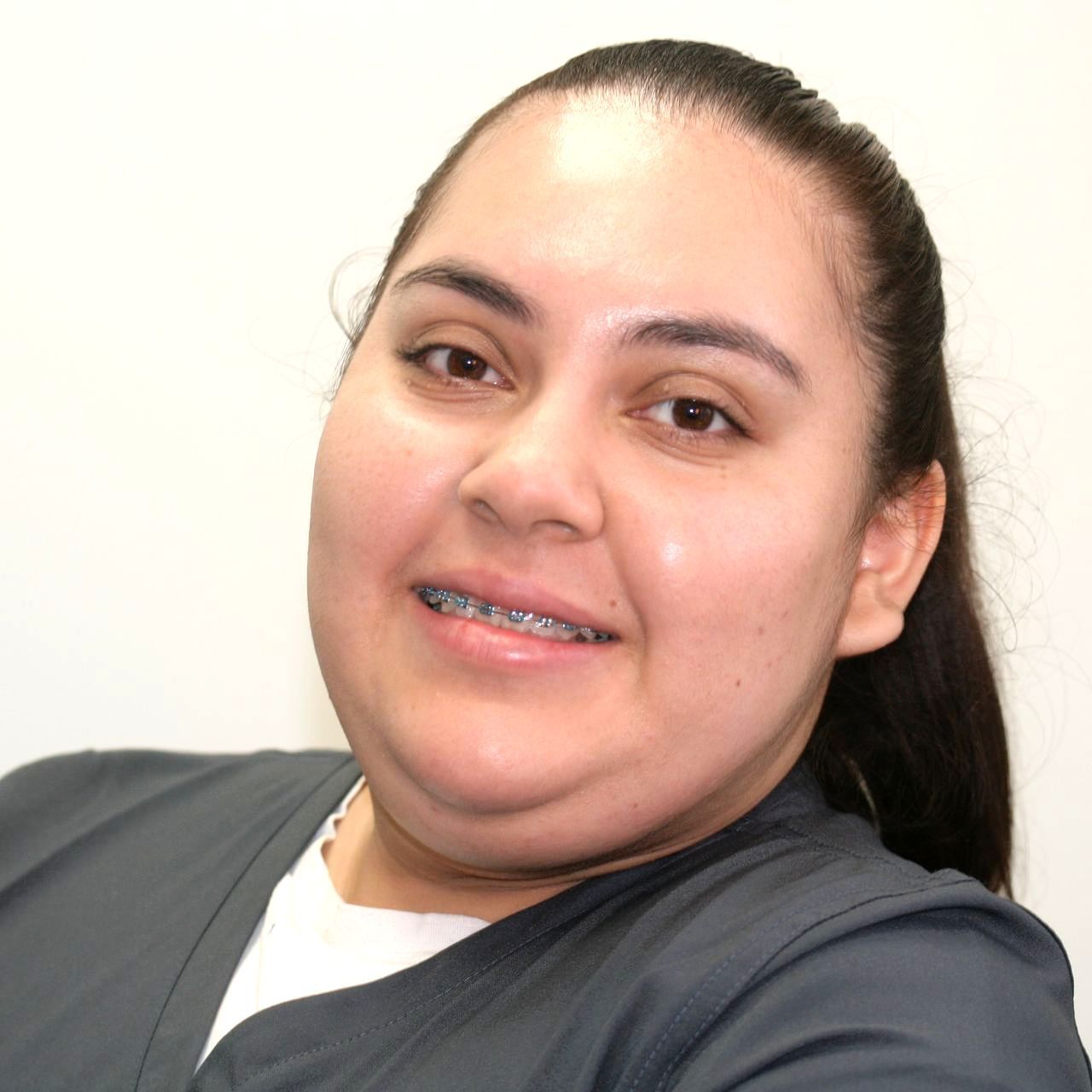 Stephanie with braces on her teeth is smiling for the camera