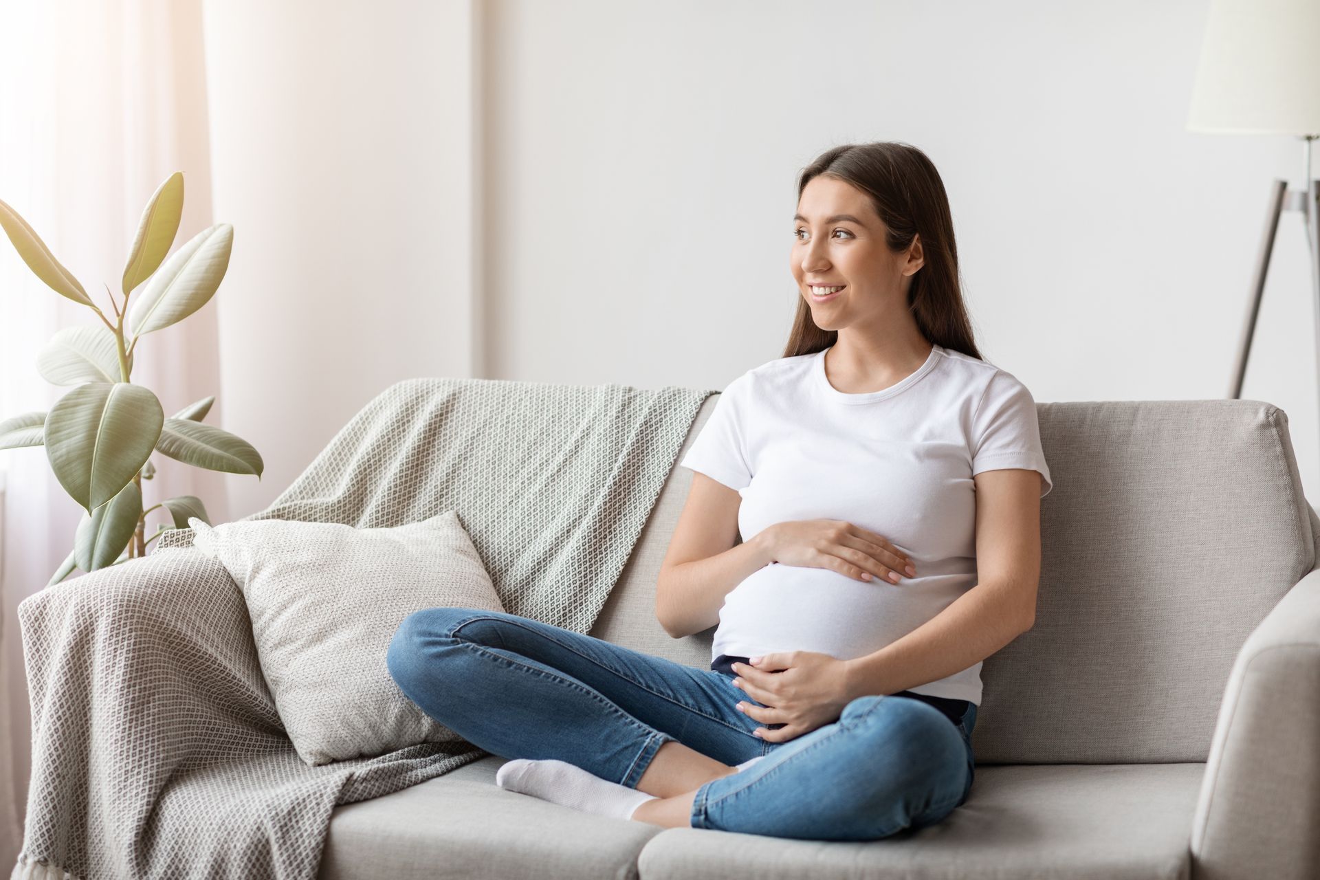 pregnant woman smiling on a couch