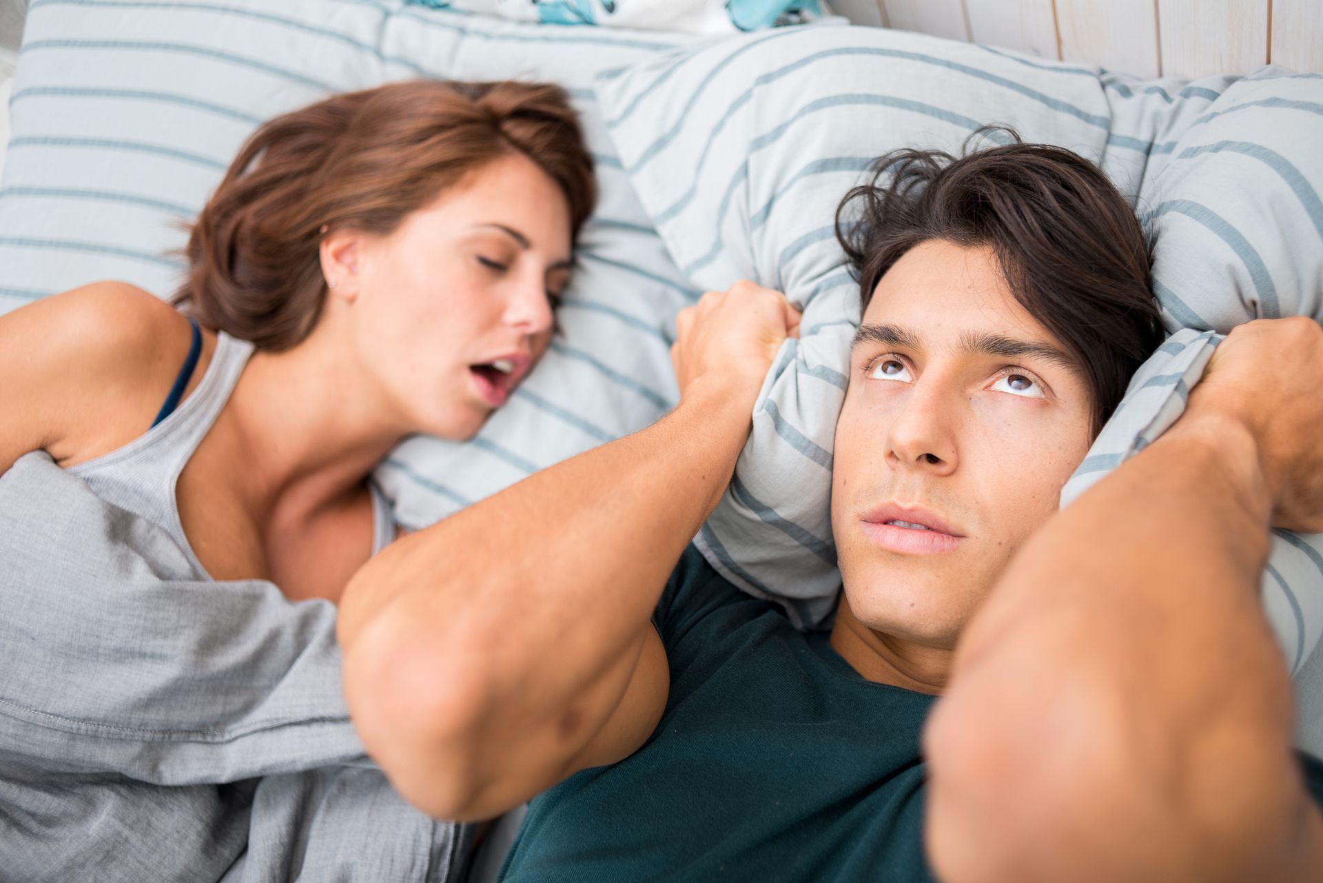 snoring woman with annoyed man