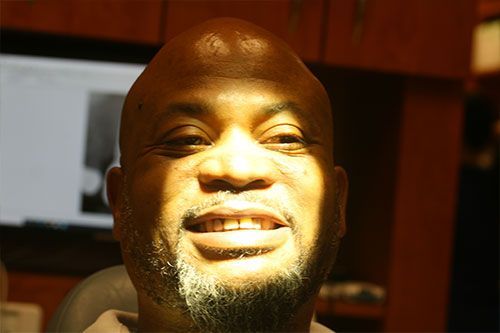 a bald man with a beard is smiling for the camera .