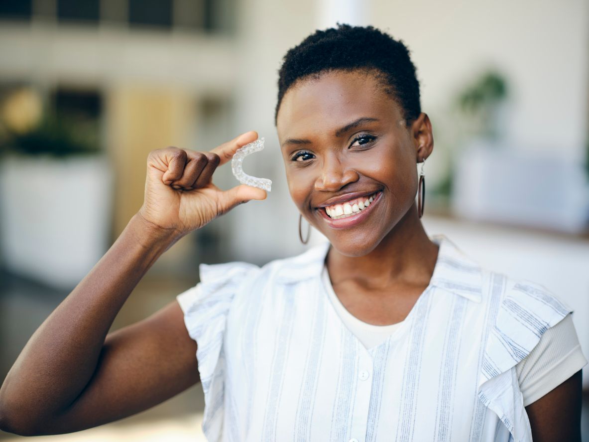 Smiling Lady holding her Invisalign