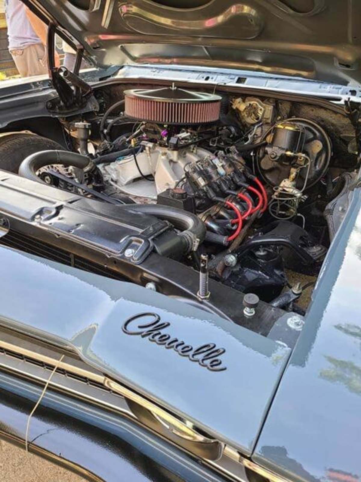A close up of a car engine with the hood open.