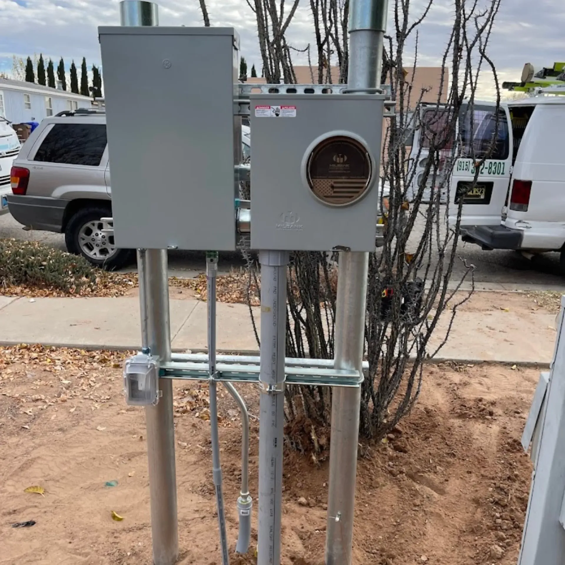 Maese Solutions  Electric  Plumbing  HVAC - A gray meter base is sitting on top of a metal pole.