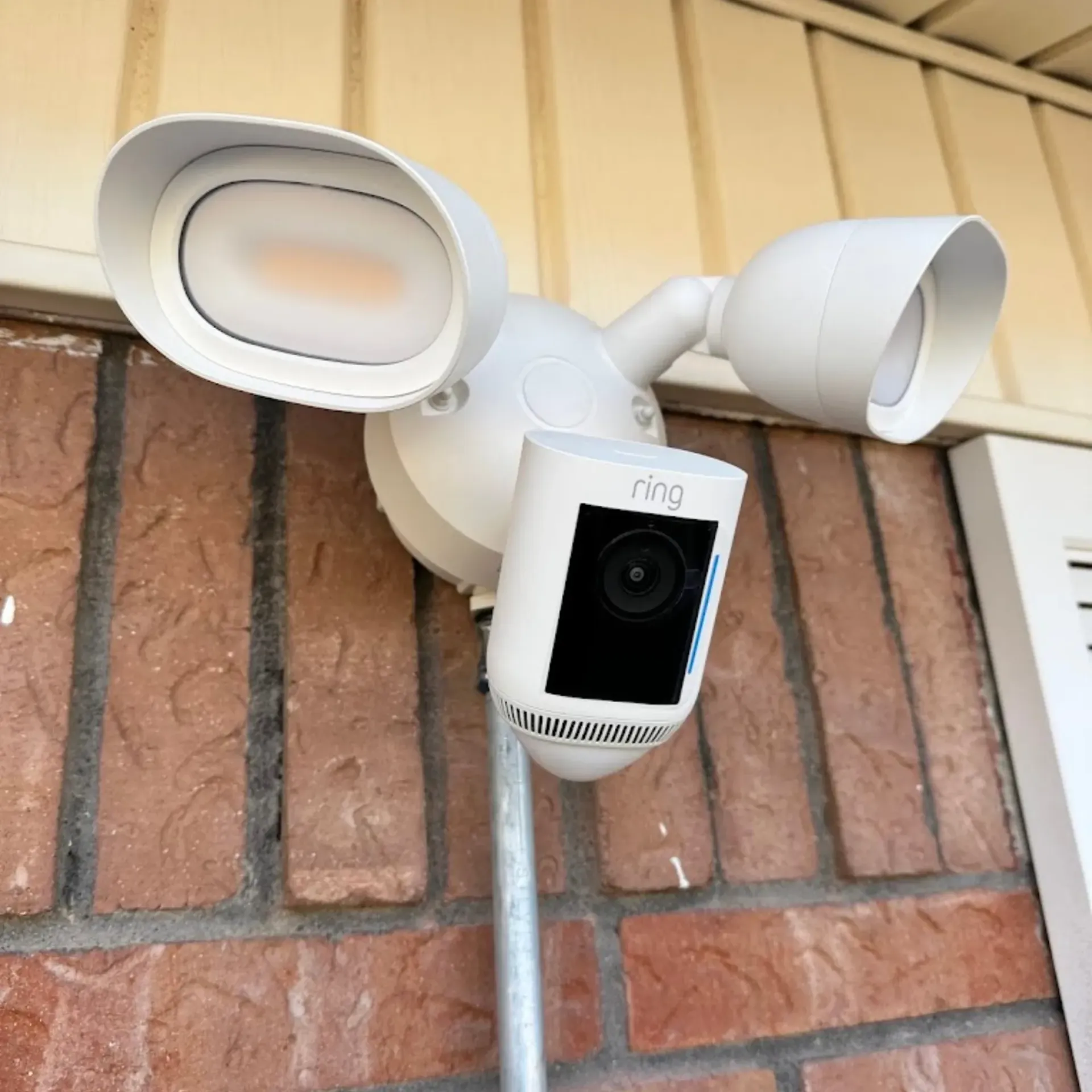 Maese Solutions  Electric  Plumbing  HVAC - A ring security camera is mounted to a brick wall.