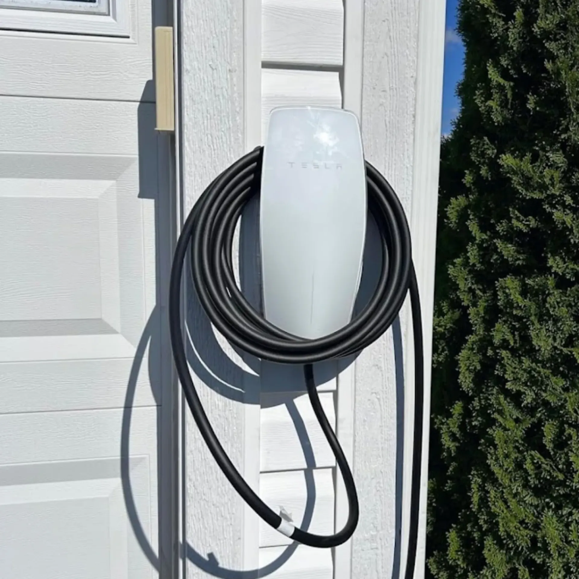 Maese Solutions  Electric  Plumbing  HVAC - A hose is hanging on the side of a garage door.