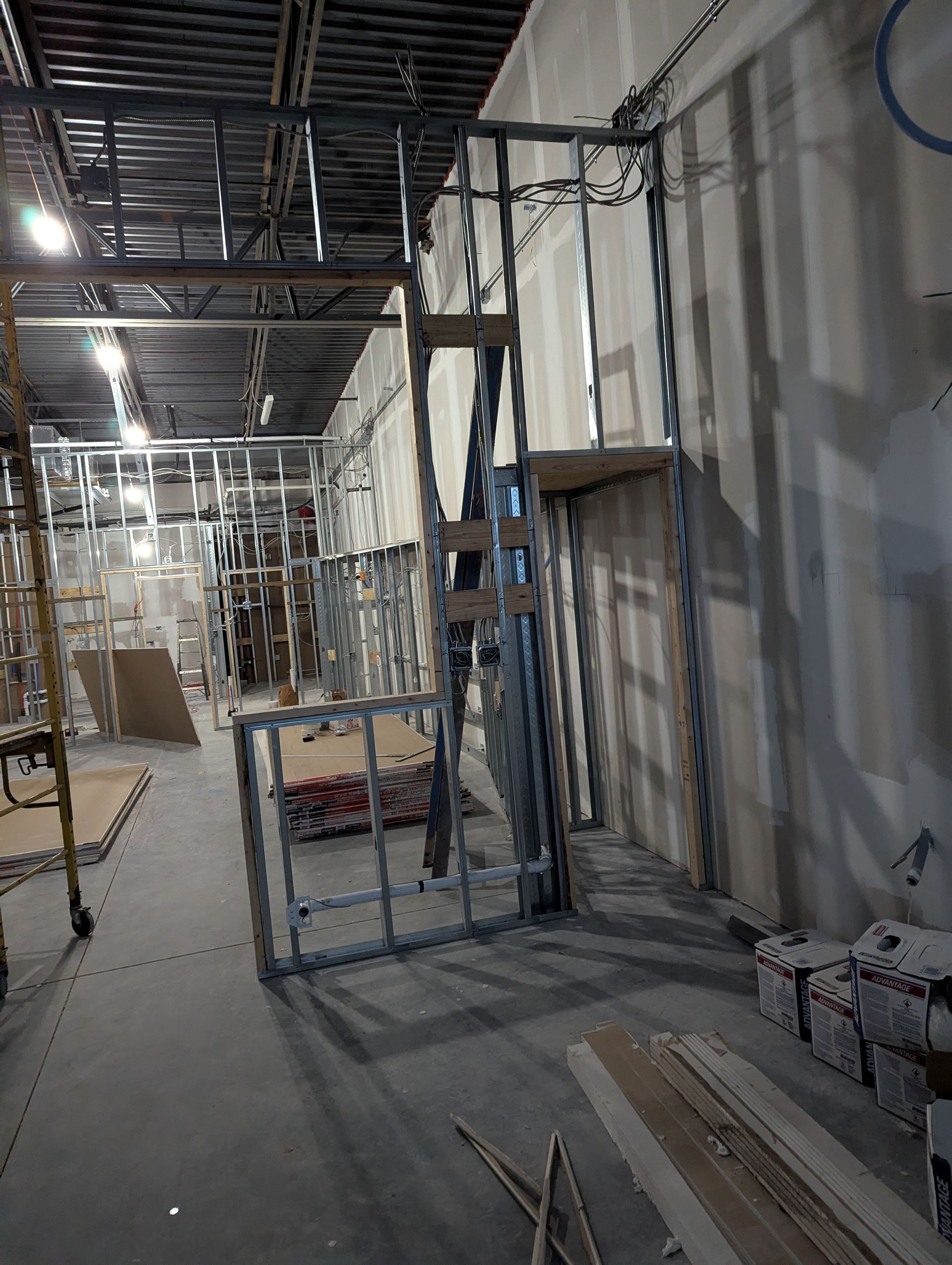 Construction site with metal wall studs framed for a doorway in an unfinished interior space.