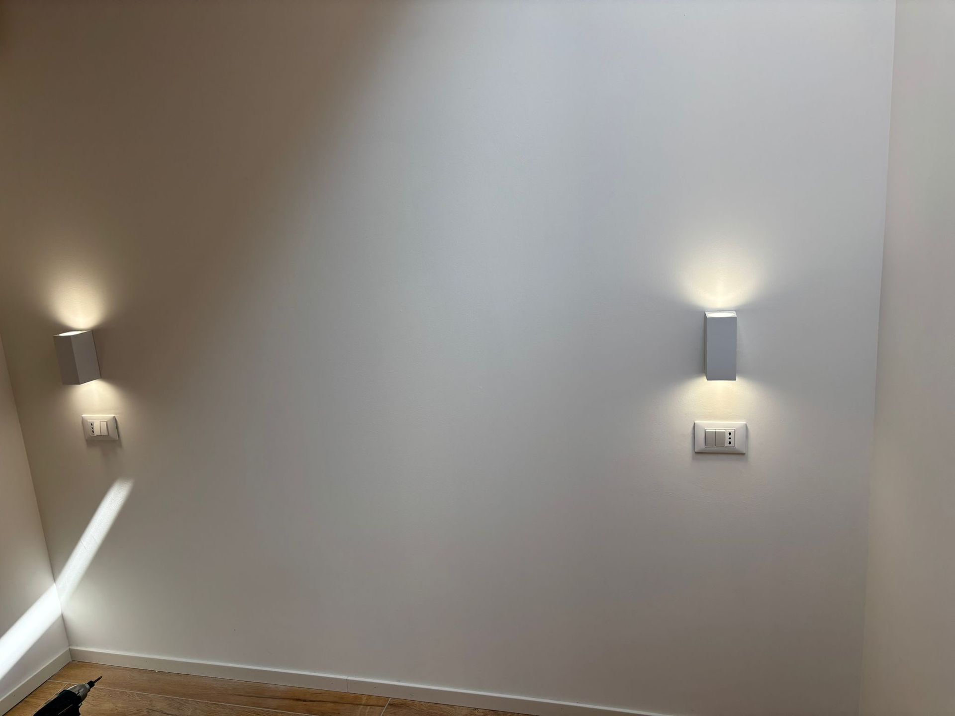Un muro bianco con due luci sopra