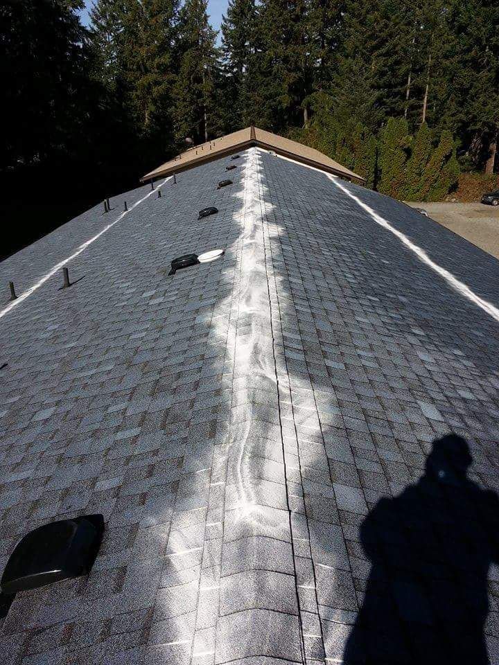 A person is standing on top of a roof with a white line on it.