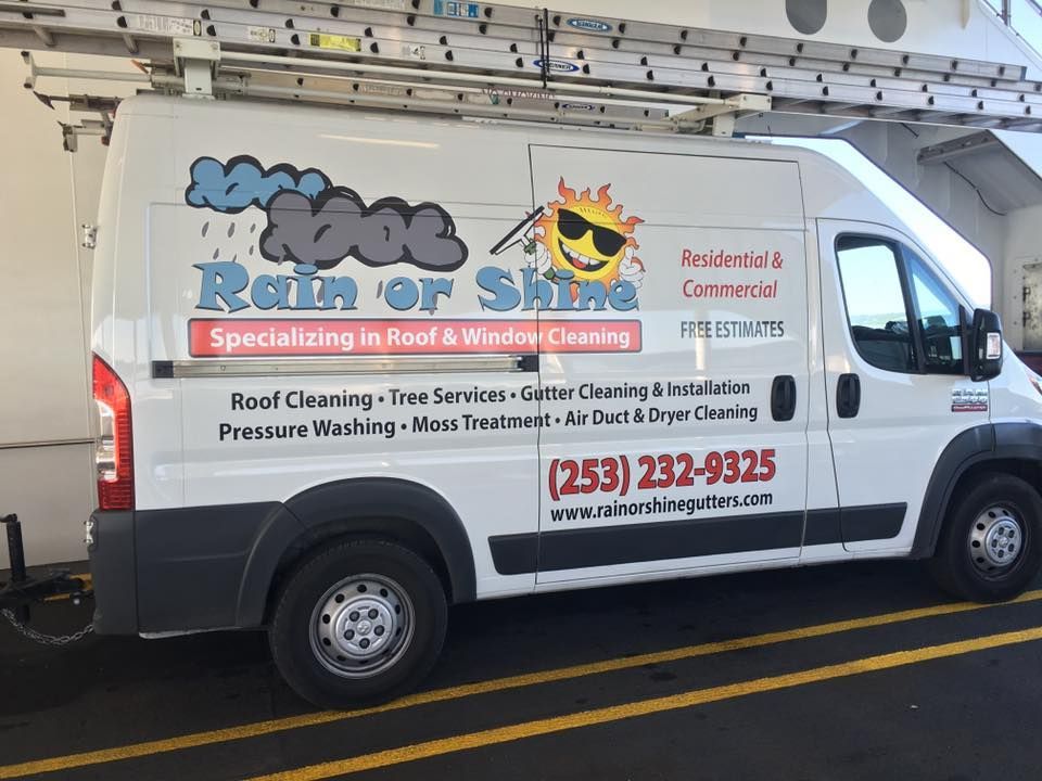 A white van with a sun on the side is parked in a parking lot.