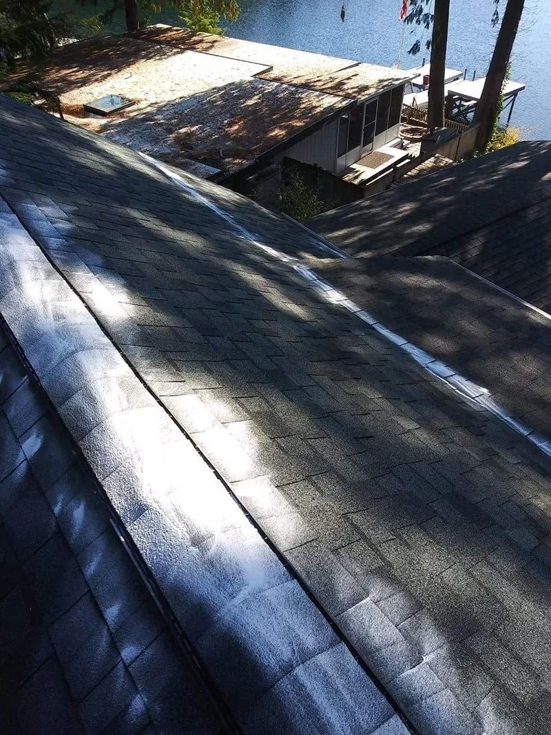 A roof with a dock in the background and a lake in the background.