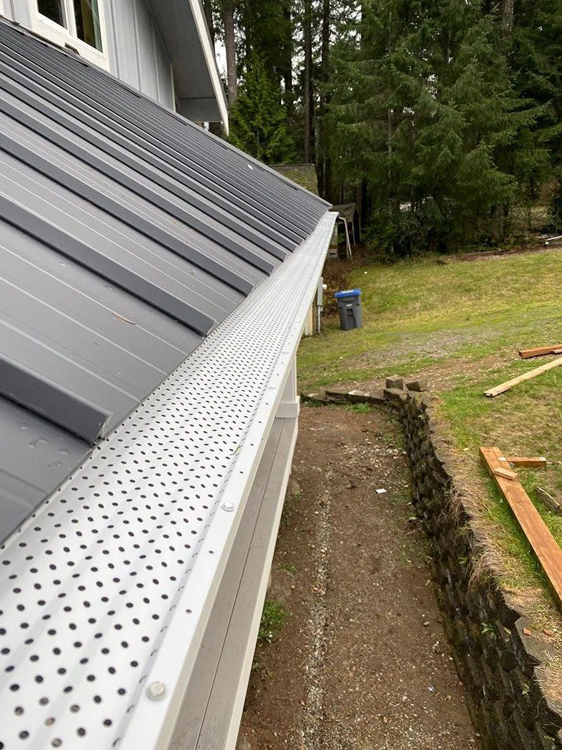 A close up of a gutter on the side of a house.