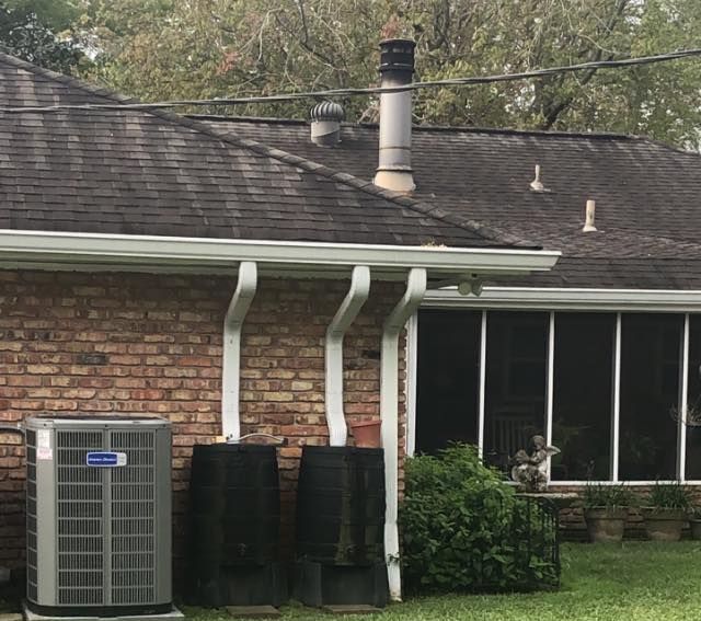 A brick house with a roof that has a chimney on it