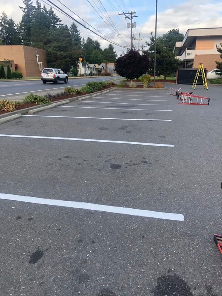 A parking lot with white lines and a ladder in the middle