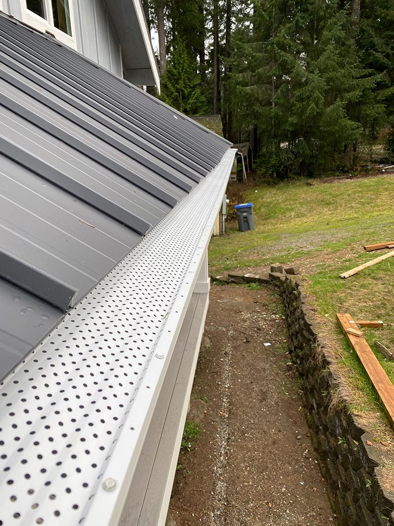 A close up of a gutter on the side of a house.