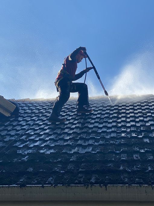 A person is standing on top of a roof with a white line on it.