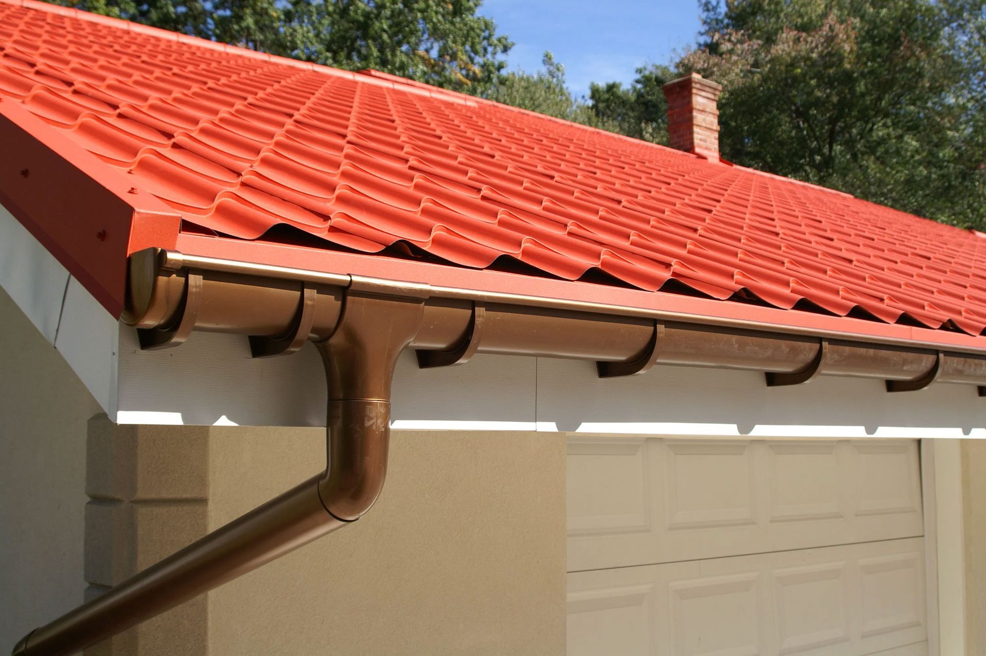 A house with a red roof and a brown gutter
