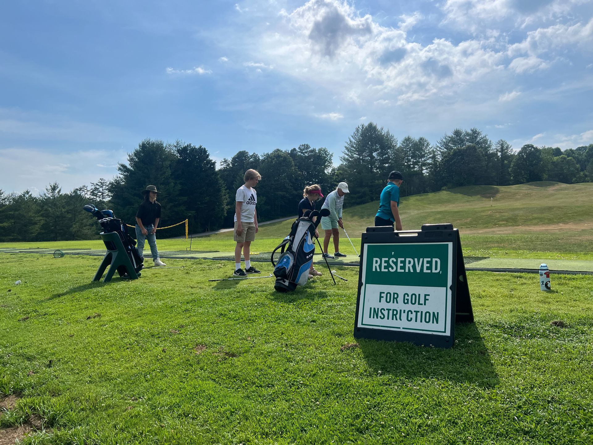 A group of people are playing golf on a lush green field. Reems Creek Golf Club. Weaverville, North Carolina.