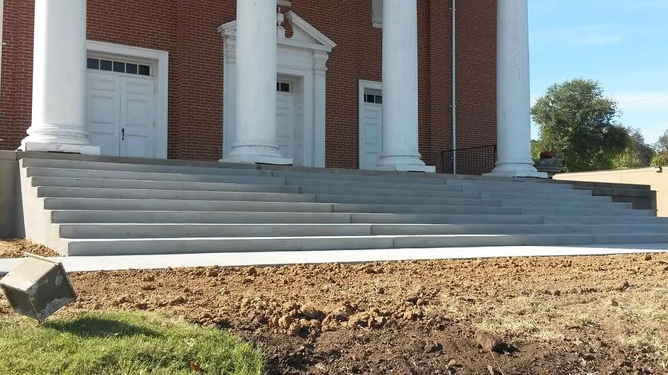 Stairs leading up to a brick building with white columns