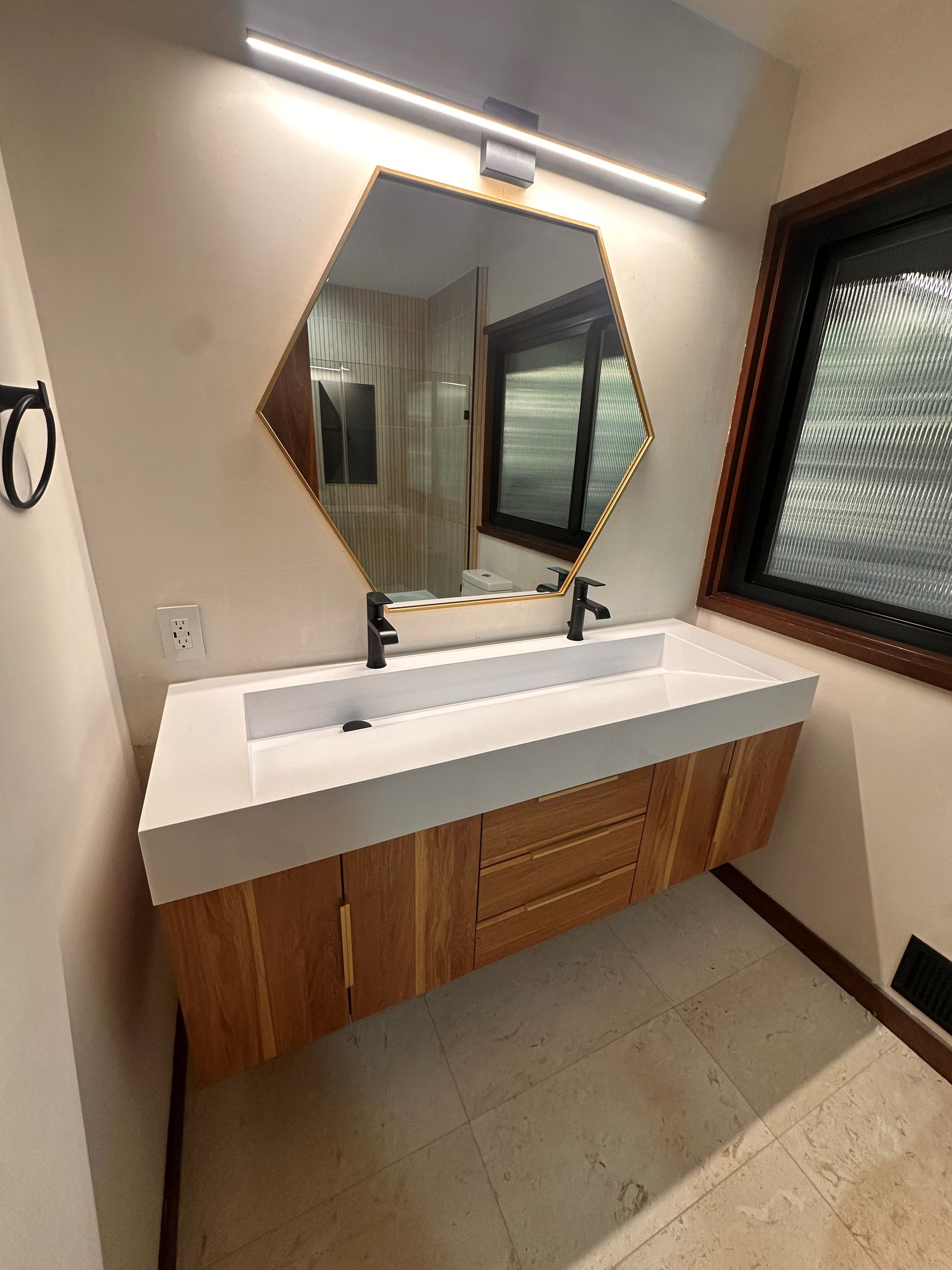 A plumber is fixing a sink in a kitchen.