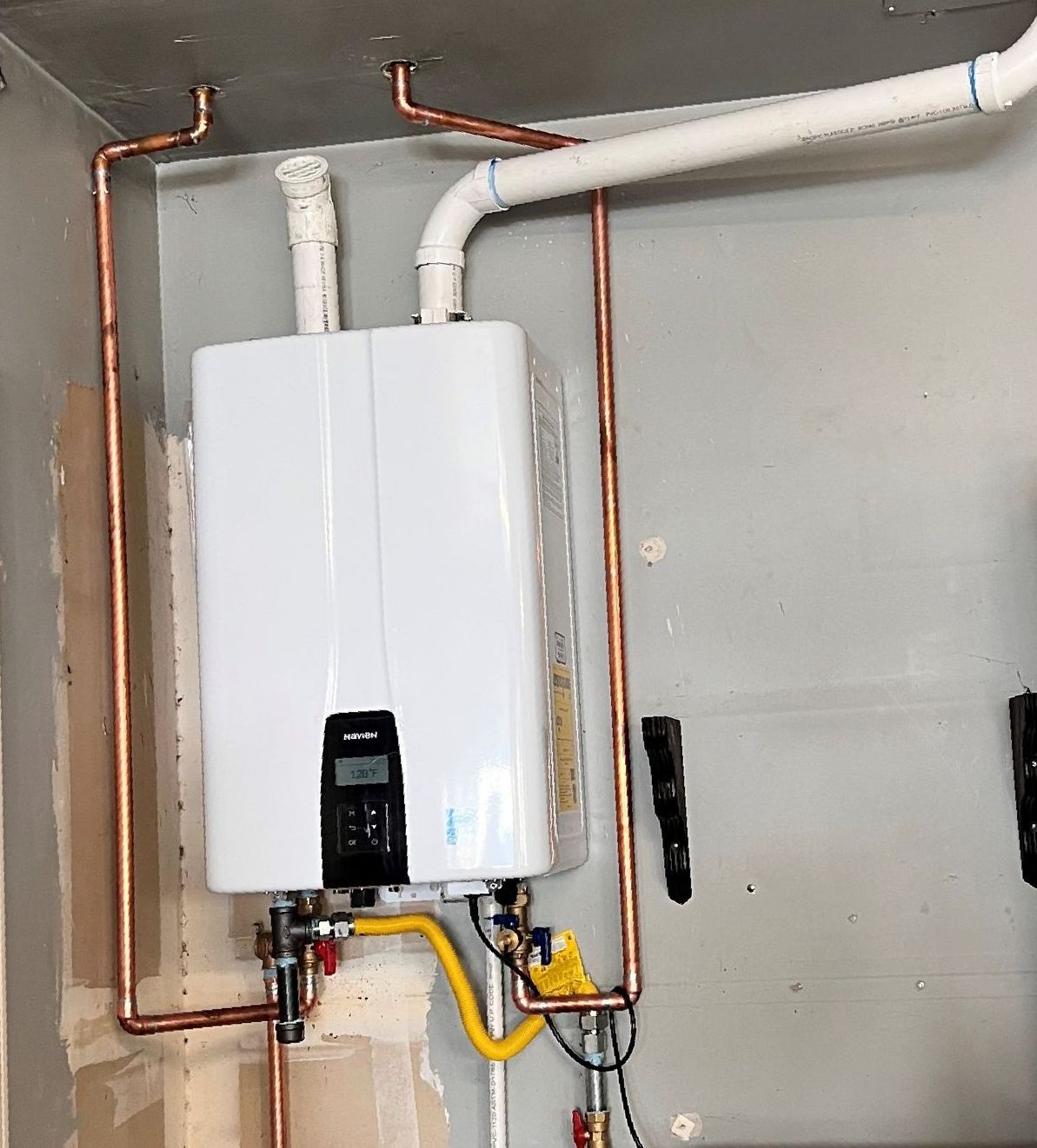 A person is adjusting the temperature of a water heater.