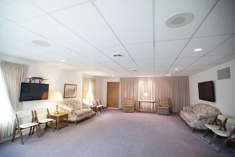 A living room with a couch , chairs , tables and a television.