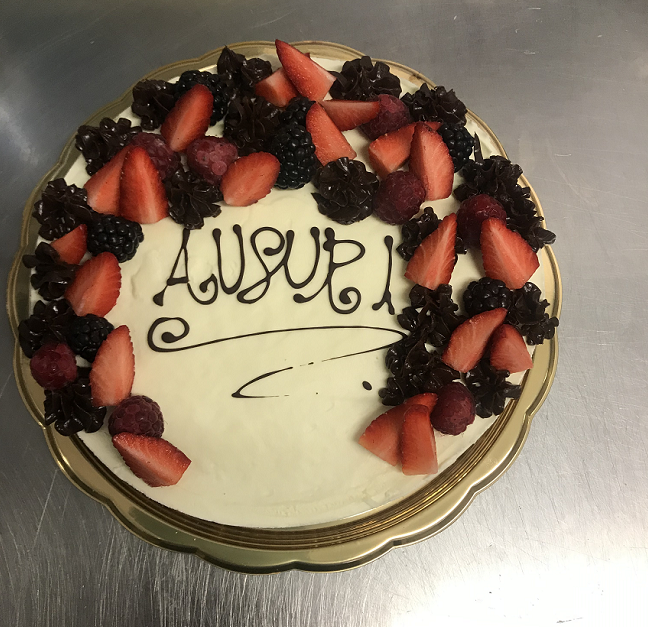 Torta con glassa bianca, guarnita con fragole, more, lamponi e