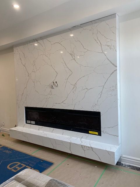 Un salon avec une cheminée et un mur en marbre.