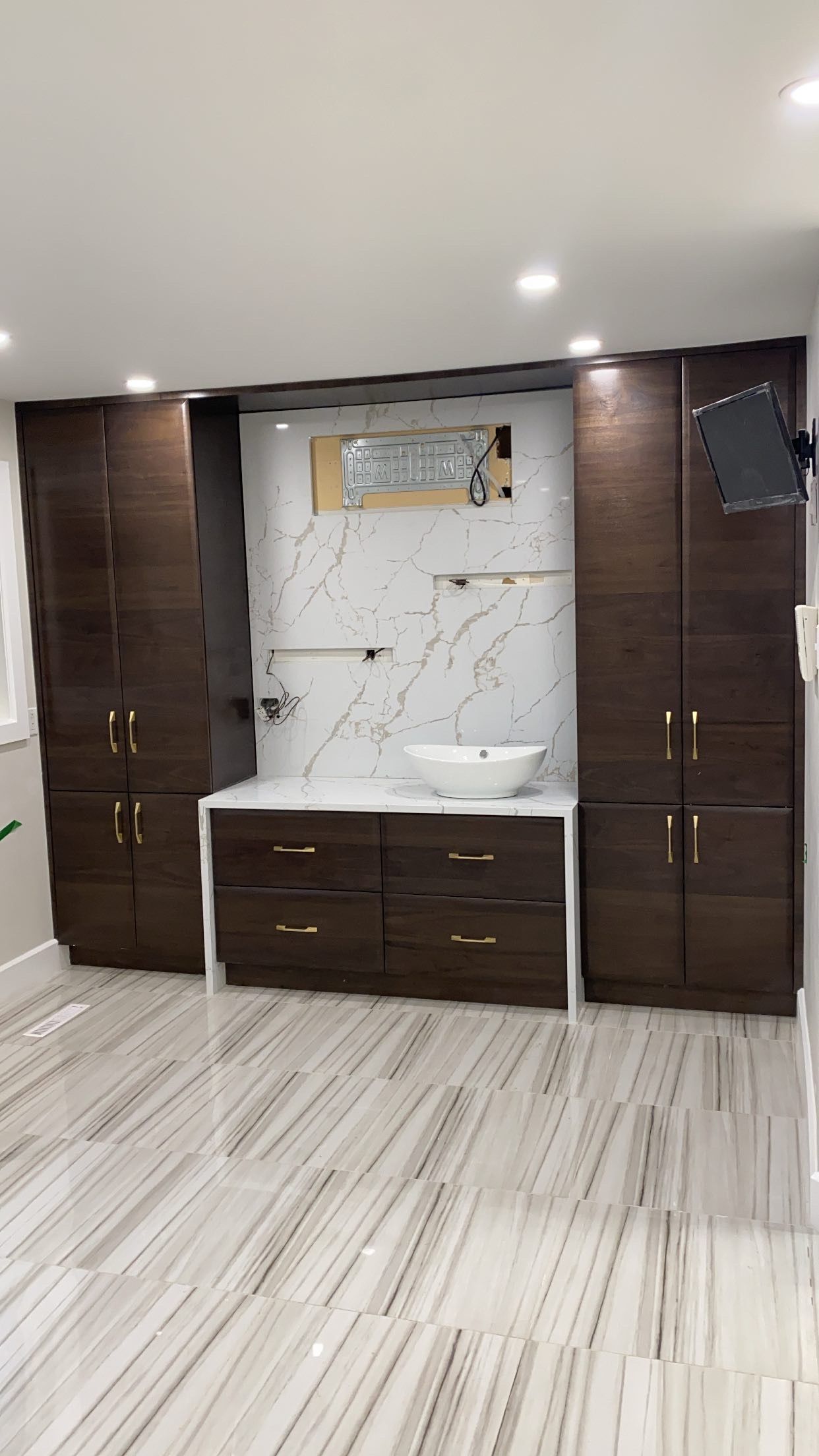 Une salle de bain avec un lavabo et beaucoup d'armoires.