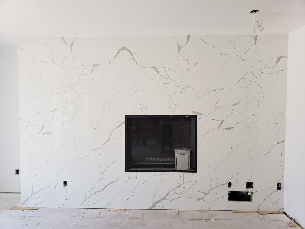 Un salon avec une cheminée et un mur en marbre.