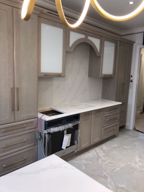 Une cuisine avec armoires en bois et comptoirs blancs