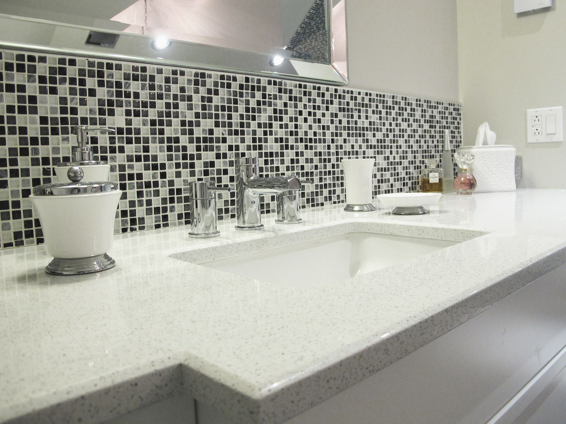 Une salle de bain avec deux vasques et un miroir.