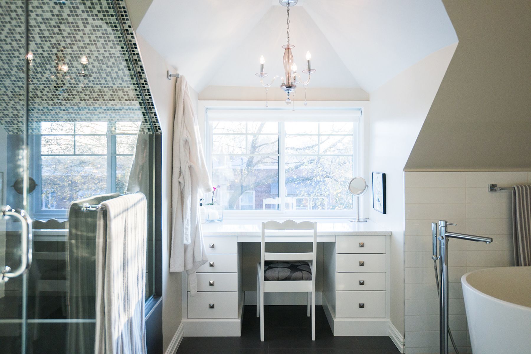 Une salle de bain avec un bureau et une chaise dans le coin