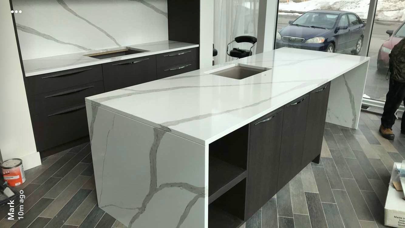 Une cuisine avec un grand îlot et un évier.