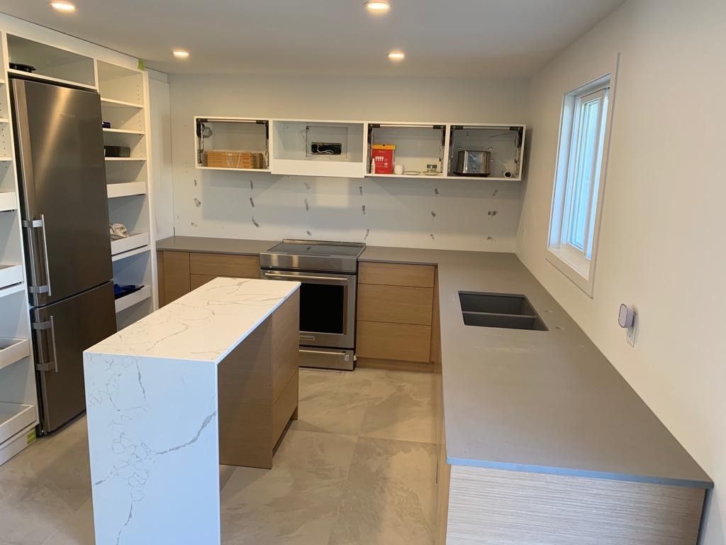 Une cuisine avec électroménagers en acier inoxydable et un grand îlot au milieu.