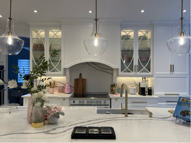 A kitchen with white cabinets , stainless steel appliances , a sink , and a stove.
