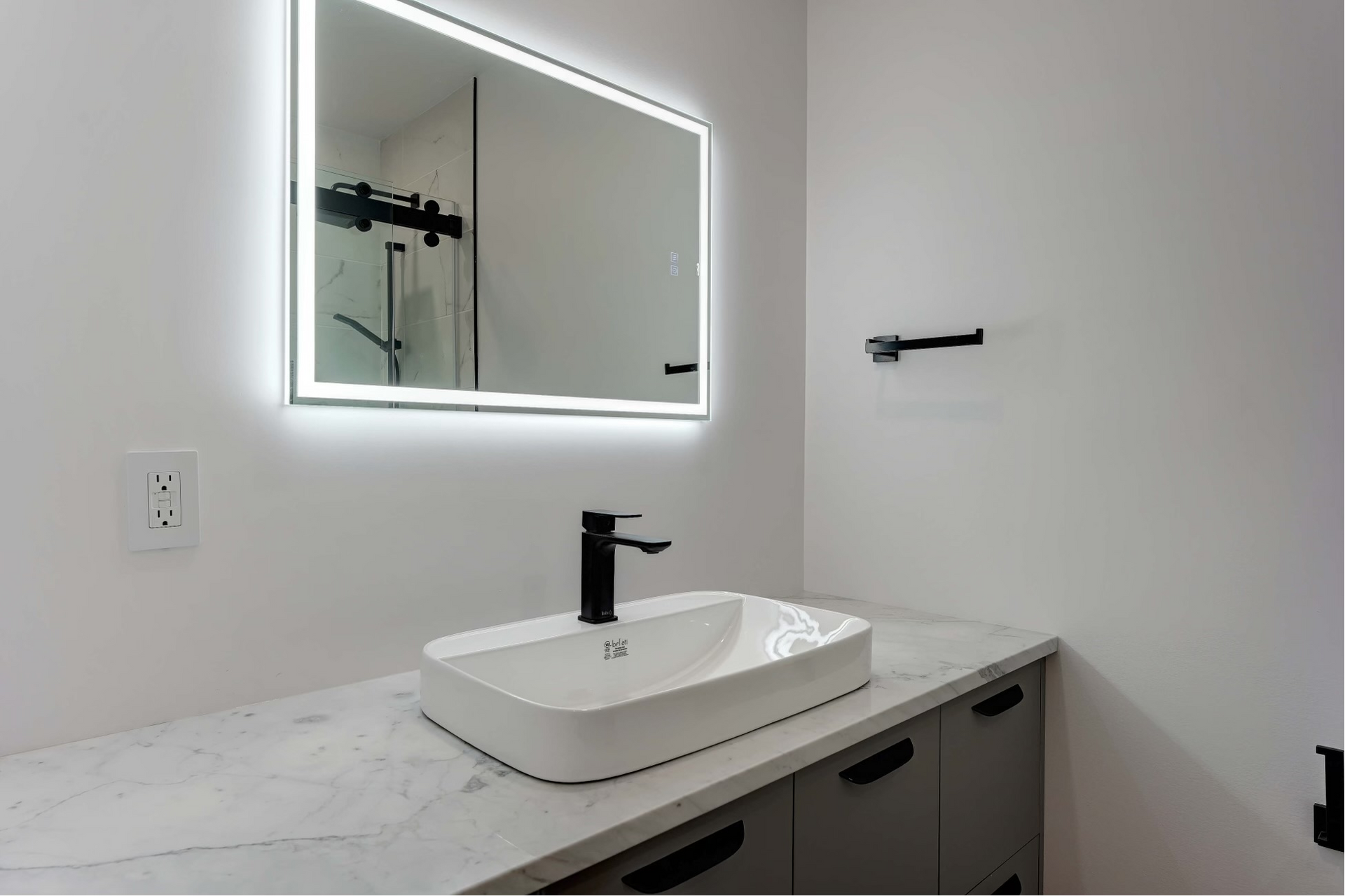 Une salle de bain avec un lavabo et un miroir au mur.