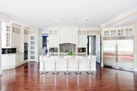 Une grande cuisine avec armoires blanches et électroménagers en acier inoxydable.