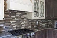 Une cuisine avec un four et une hotte au dessus.