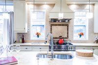 Une cuisine avec évier, cuisinière et fenêtre.