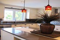 Une cuisine avec un vase de fleurs sur le comptoir.