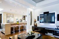 Un salon avec une télévision écran plat au mur et une table basse.