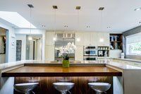 Une cuisine avec un grand îlot et des tabourets.