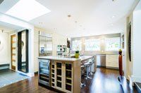 Une cuisine avec un grand îlot et des électroménagers en acier inoxydable.