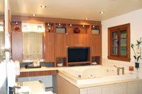 Une salle de bain avec baignoire jacuzzi et télévision écran plat.