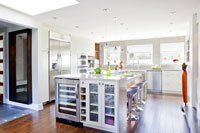 Une cuisine avec un grand îlot et des électroménagers en acier inoxydable.