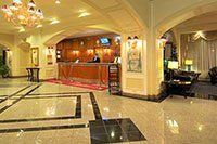 Un hall d'entrée d'hôtel avec un comptoir de réception et un lustre.