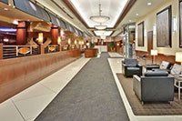 Un long couloir avec des chaises et des tables dans le hall d'un hôtel.