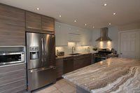 Une cuisine avec appareils électroménagers en acier inoxydable et comptoirs en granit.