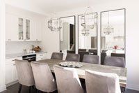 Une salle à manger avec une longue table et des chaises et une cuisine.